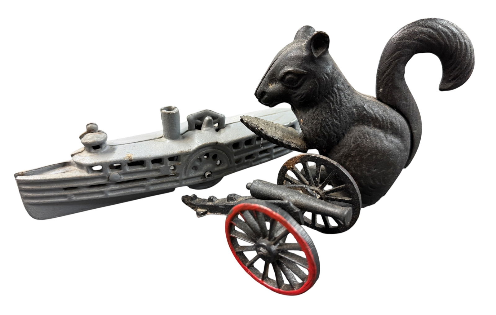 Trio of Cast Iron Toys: Trio of Cast Iron Toys- Squirrel Nutcracker, Steamship with Wheels, and a toy cannon.