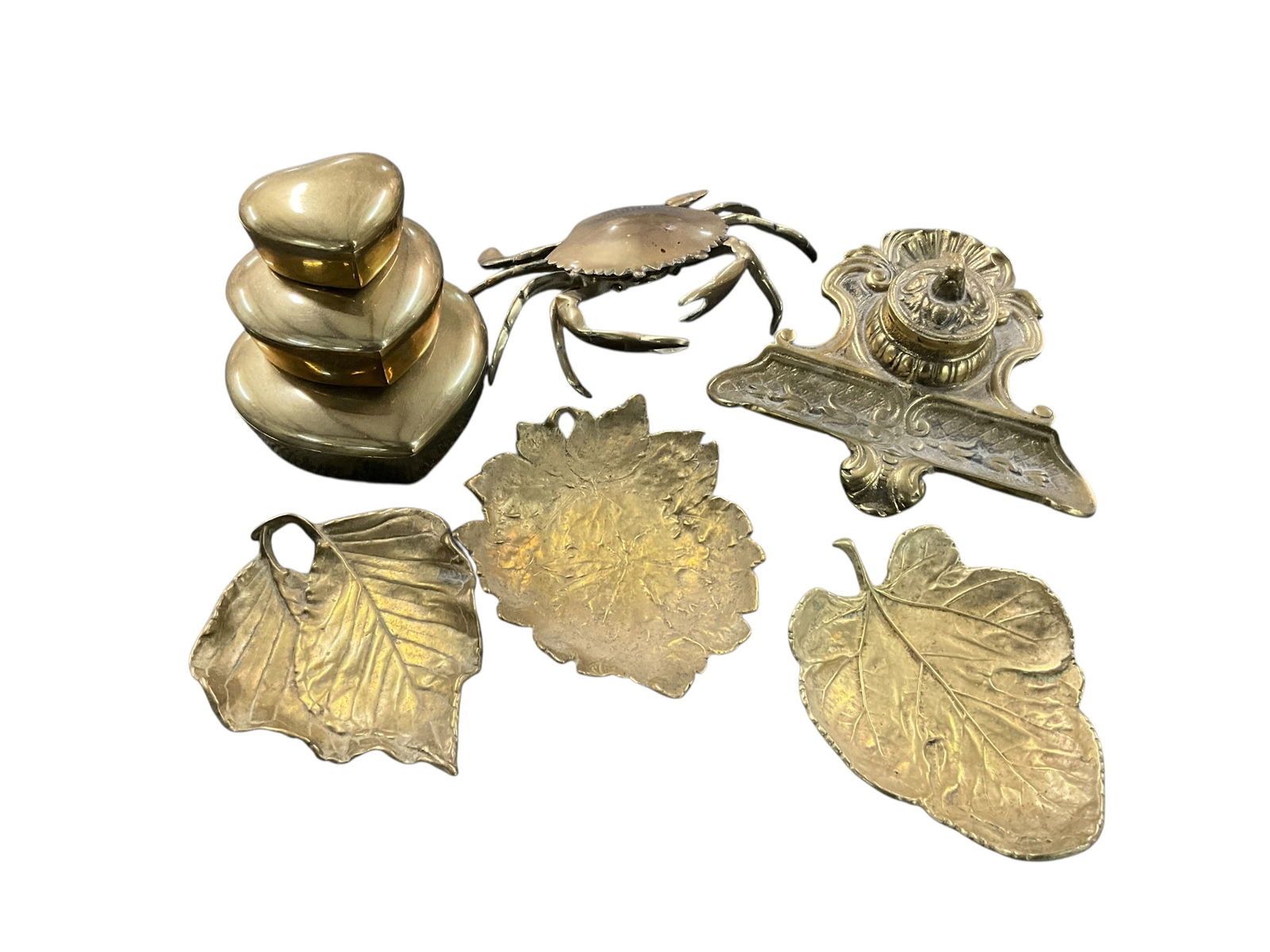Group of Brass Desk Items: Group of Brass Desk Items- an inkwell (missing ink cup), a crab ashtray, three leaf shaped pin dishes, and three nested heart shaped covered boxes.