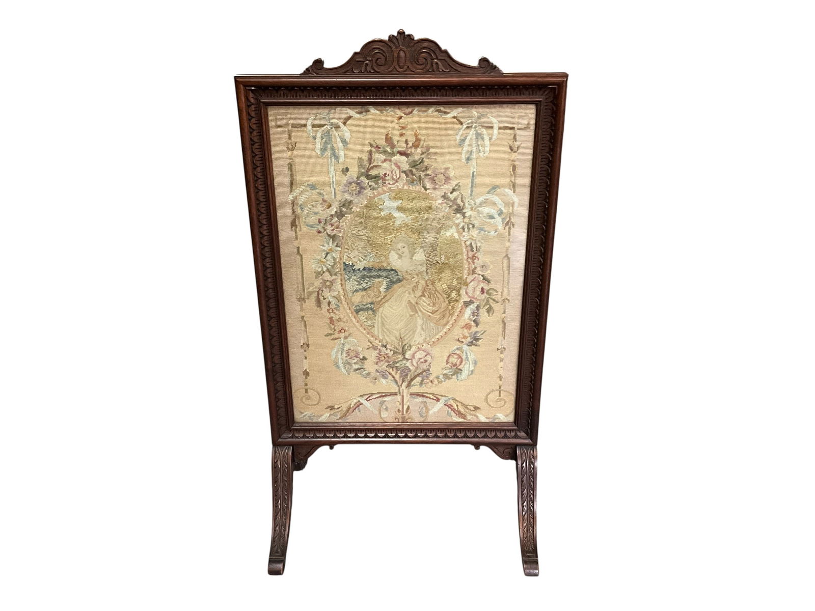 Early Victorian Needlepoint Firescreen: Early Victorian (or Georgian) Needlepoint Firescreen. Needlepoint under glass of a lovely maiden in a central medallion. Some fading of the needlepoint. Acanthus scroll feet. Original fabric backing