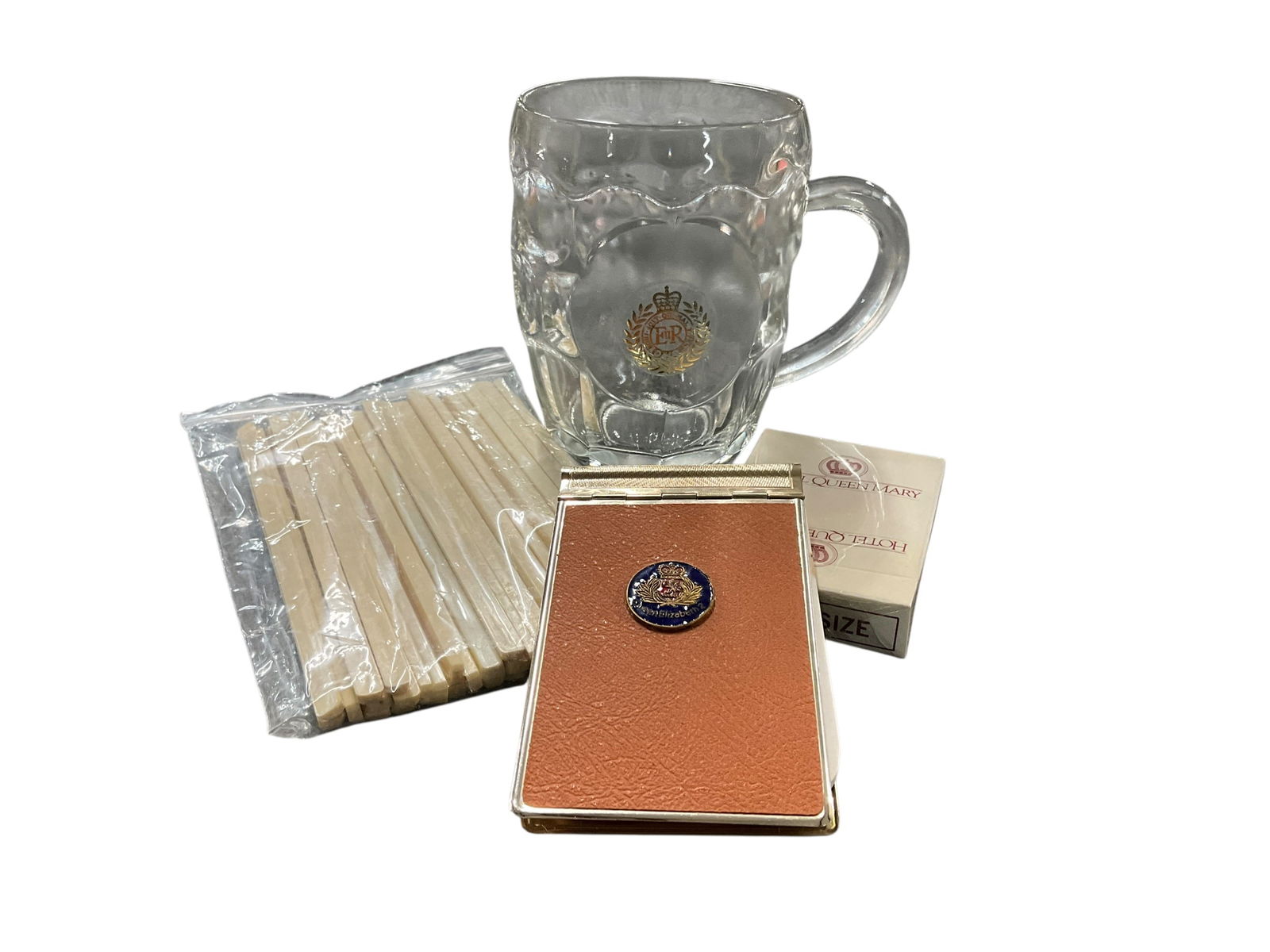 Queen Elizabeth 2/Cunard Souvenir Items: Queen Elizabeth 2/Cunard Souvenir Items. Beer mug, notepad, Cunard swizzle sticks, Hotel Queen Mary playing cards.