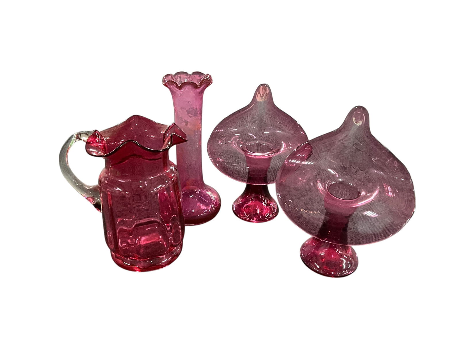 Cranberry Glass Lot: Cranberry Lot. A pair of 6" Jack-in-the-Pulpit vases, a 6.5" bud vase, and a 5.5" blown glass pitcher with ruffled edge and applied handle. The bud vase has staining from hard water.