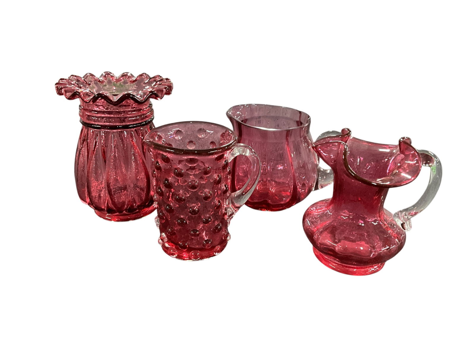 Cranberry Glass Lot: Cranberry Lot. A fluted Ruffled rim vase, approx. 5" high, and three small cranberry pitchers of various styles and sizes.