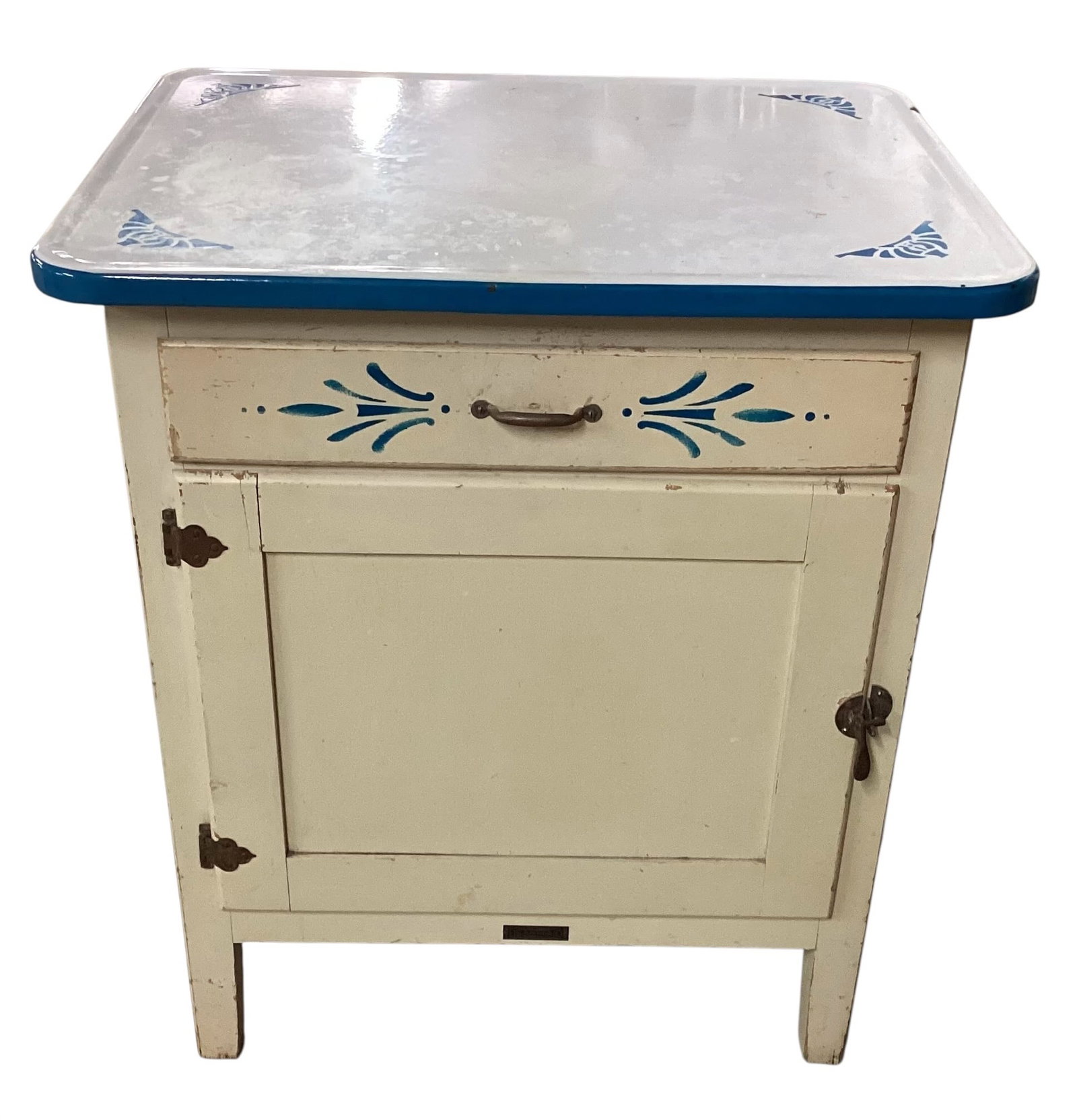 Vintage Dearman Enamel-Top Kitchen Cabinet with Pull-Out Wire Shelf: Vintage Dearman kitchen cabinet featuring cream-painted wood construction with white enamel work surface accented by cobalt blue trim and floral corner stencil decoration. Cabinet includes a divided u