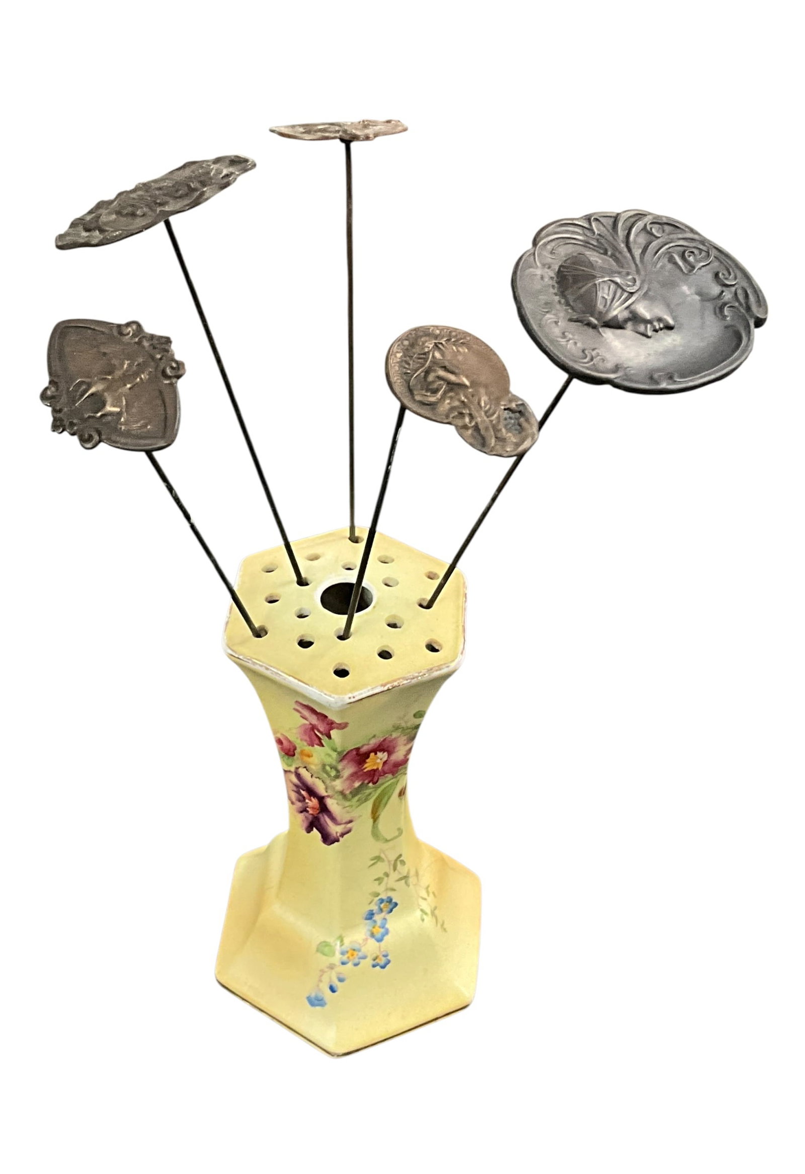 Hand-Painted Porcelain Hatpin Holder with Hatpins: Antique hand-painted porcelain hatpin holder featuring a soft yellow ground with delicate floral decoration in pink, purple, and blue tones. The form is hexagonal with a flared base and a pierced top 