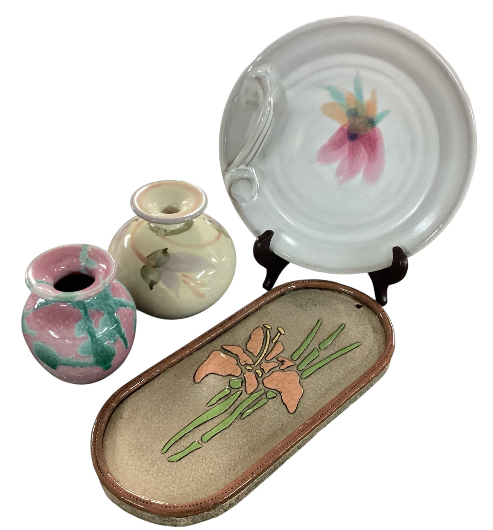 Four-Piece Studio Pottery Group Including Floral Tray, Handled Plate, and Two Bud Vases (One Signed): A four-piece collection of studio pottery featuring soft pastel glazes and floral motifs. Includes a rectangular tray with rounded corners, decorated with a raised stylized floral design in peach and 