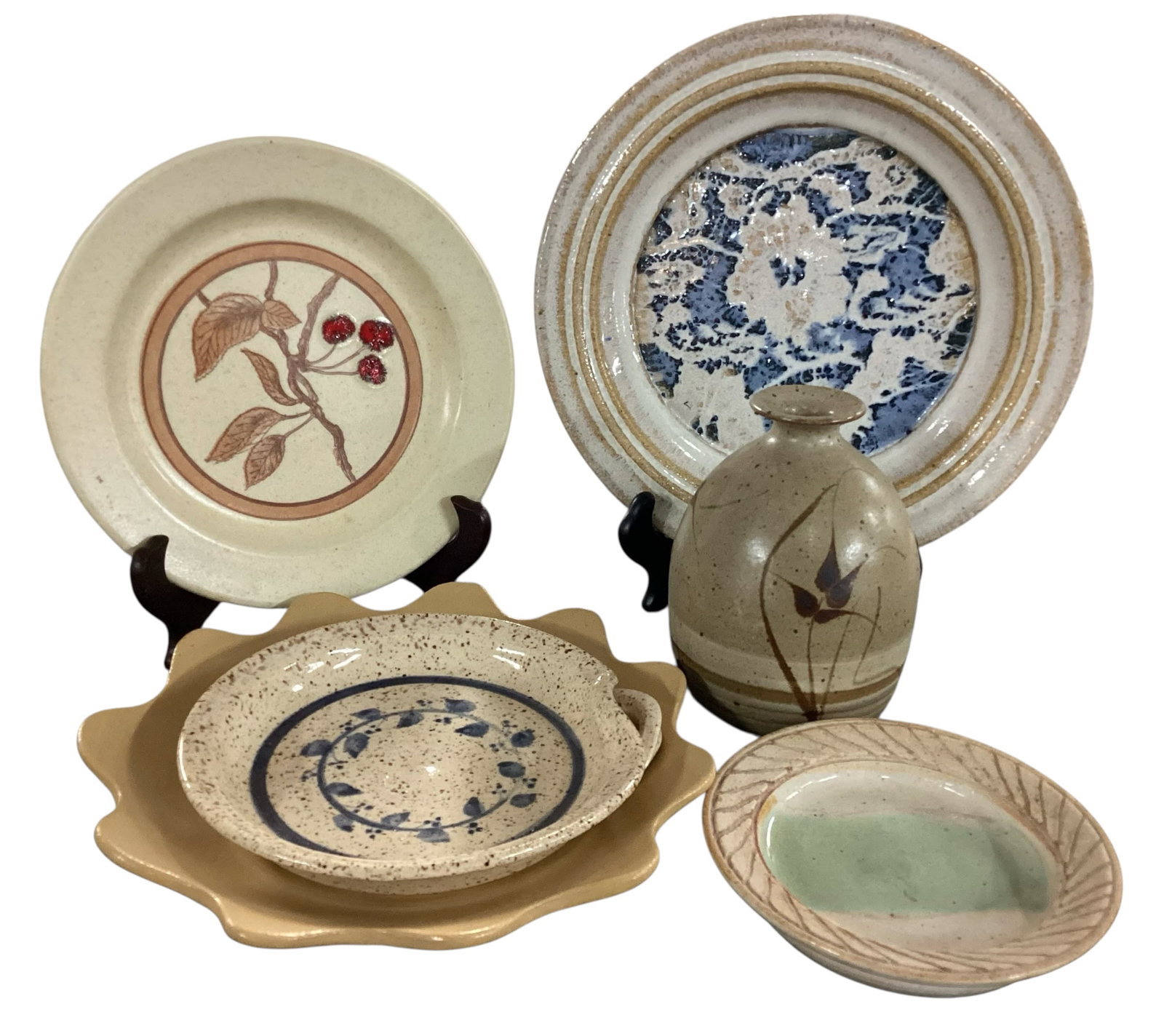 Five-Piece Studio Pottery Group Including Signed Hanging Plate and Vase: A five-piece grouping of studio pottery featuring complementary earth-tone glazes and hand-decorated motifs. Includes a signed hanging wall plate with concentric banding and a central abstract blue an