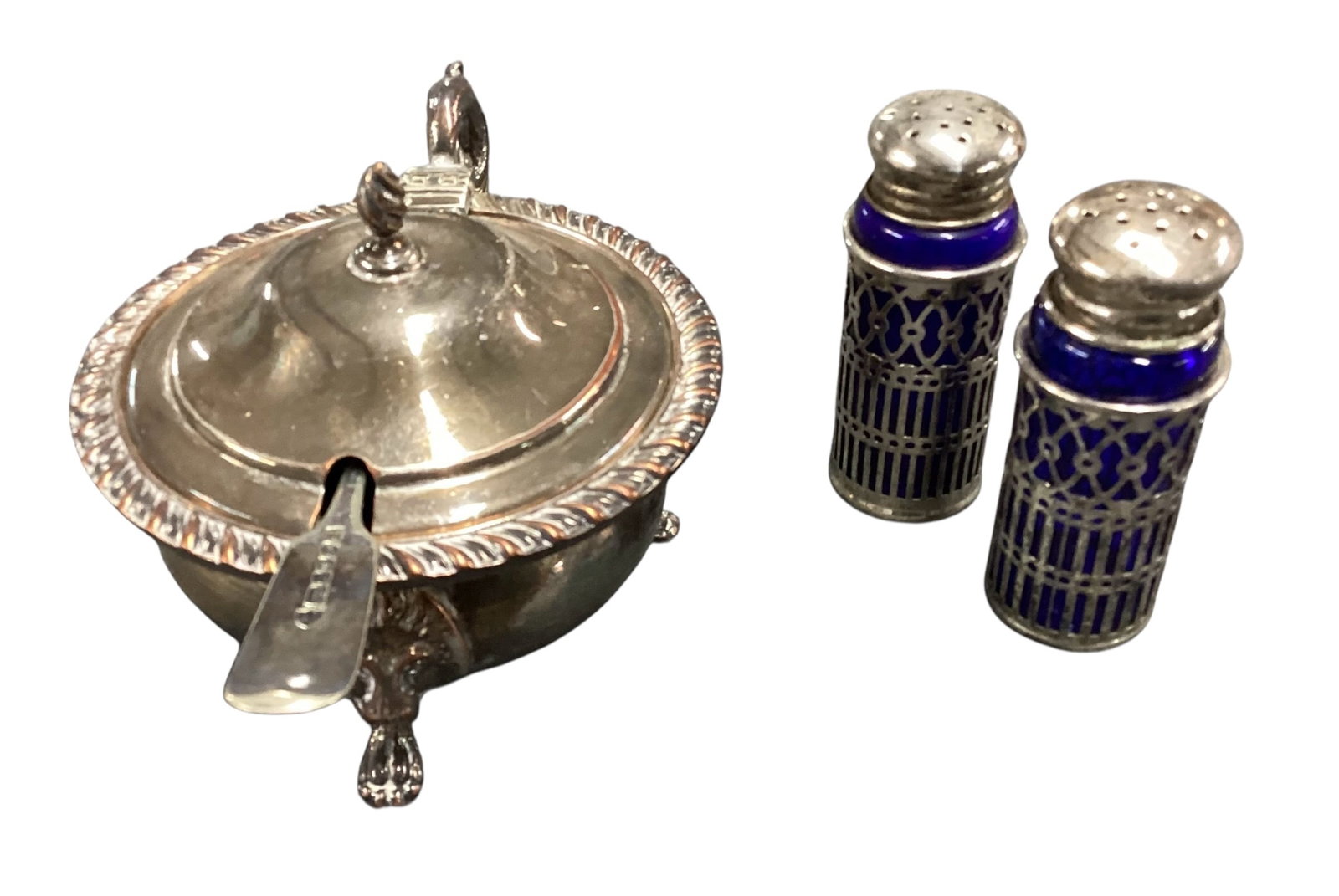 Silver Plate Mustard Pot with Cobalt Glass Liner and Matching Salt & Pepper Shakers: Vintage silver plate condiment set including a covered mustard pot with cobalt blue glass liner and matching serving spoon, accompanied by a pair of cobalt blue glass salt and pepper shakers in pierce