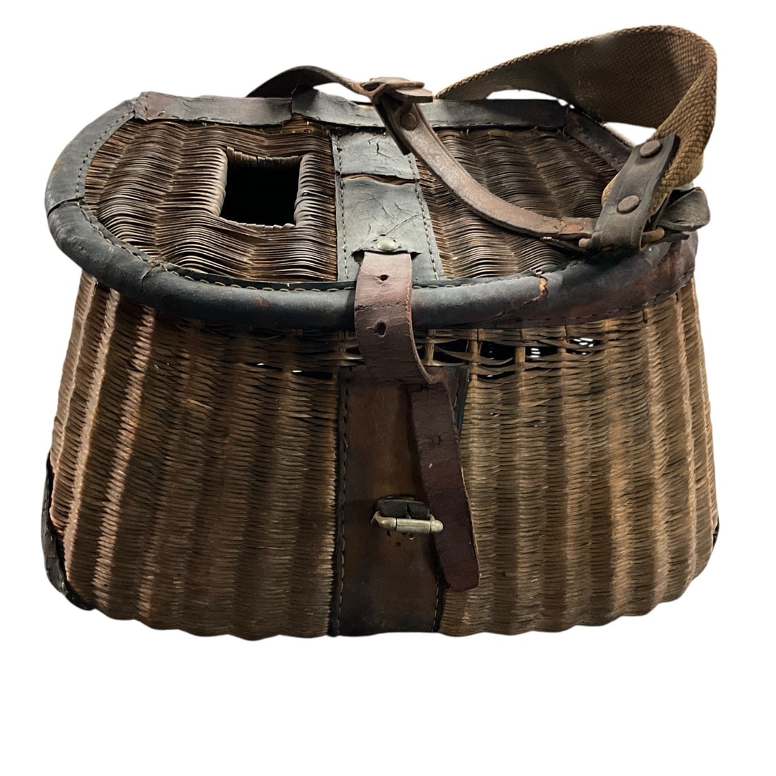 Antique Woven Fishing Creel Basket with Shoulder Strap: Antique woven fishing creel basket featuring traditional wicker construction with leather trim, hinged lid, buckle closure, and canvas shoulder strap. Classic form with rectangular body and top access