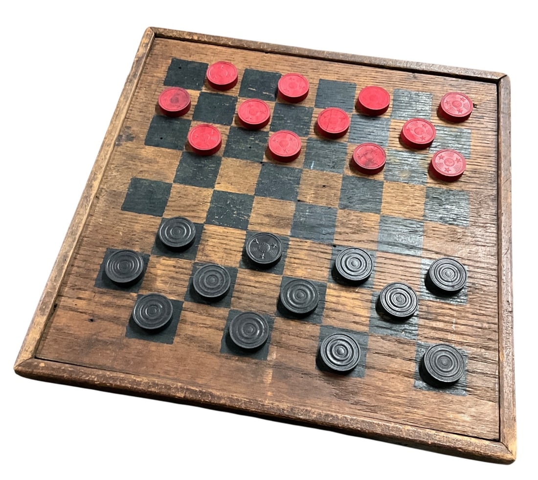 Antique Wooden Checkerboard Game with Turned Wood Pieces: Antique wooden checkerboard game featuring a hand-painted black square playing surface on a solid wood board with molded edge frame. Includes a complete set of red and black turned wood checker pieces