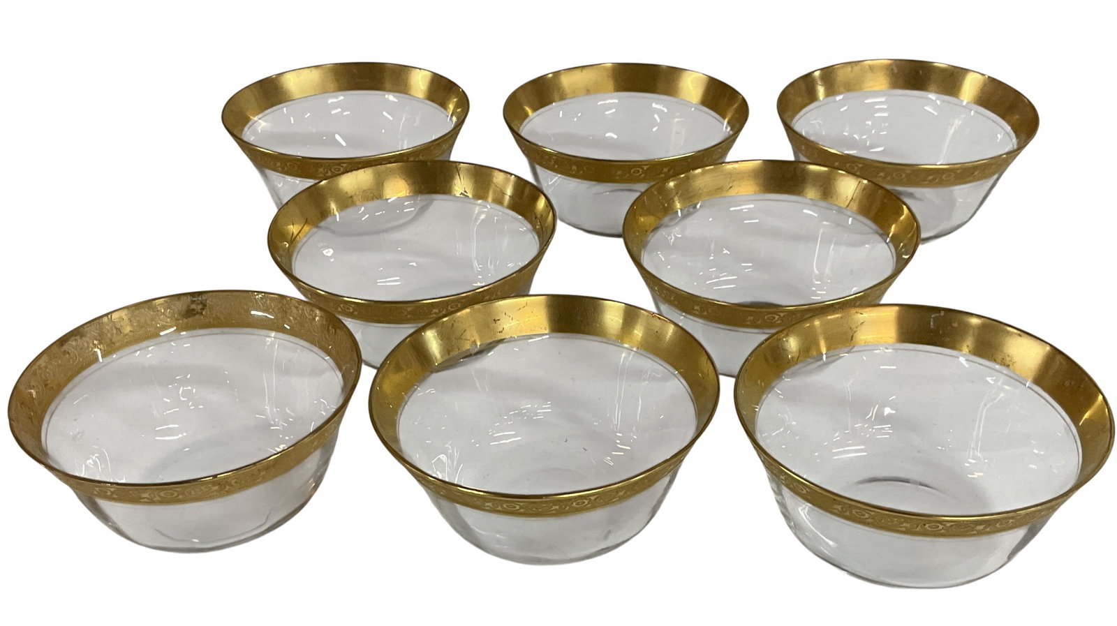 Set of Eight Gold Encrusted Glass Finger or Dessert Bowls: Vintage set of eight clear glass finger or dessert bowls featuring elegant gold encrusted rims with decorative scrolling motifs. Attractive table service pieces suitable for formal dining,