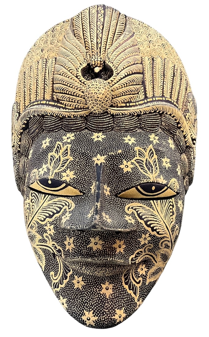 Hand-Carved Indonesian Batik Decorated Female Mask: Finely hand-carved wooden wall mask featuring an elegant female face with elaborate coiffure and intricate batik-style decoration throughout. Executed in black and natural tones with dense floral,