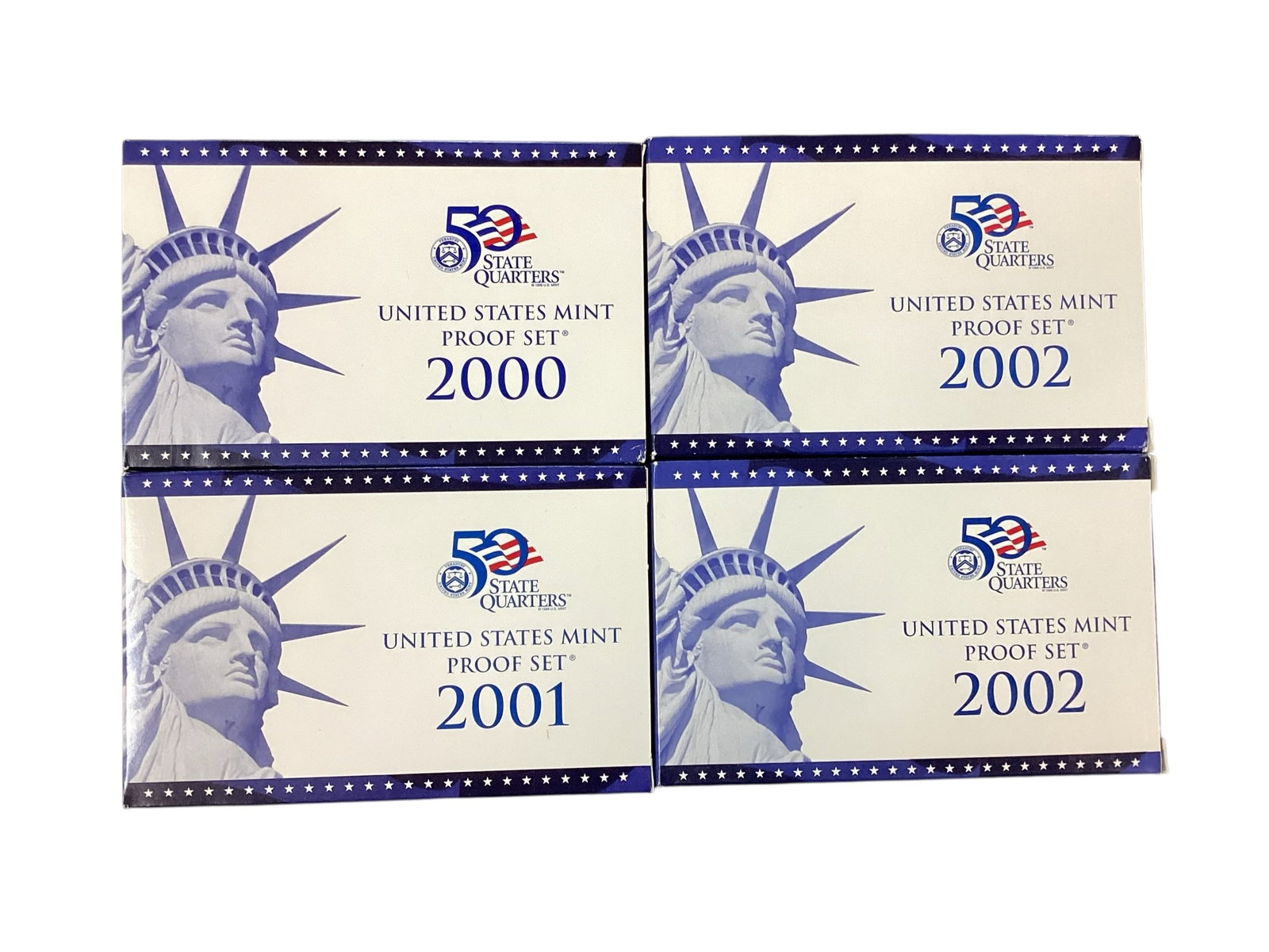 Four United States Mint State Quarters Proof Sets, 2000-2002: Collection of four United States Mint State Quarters Proof Sets including one 2000 set, one 2001 set, and two 2002 sets. Each official U.S. Mint proof set includes proof strike circulating coinage and
