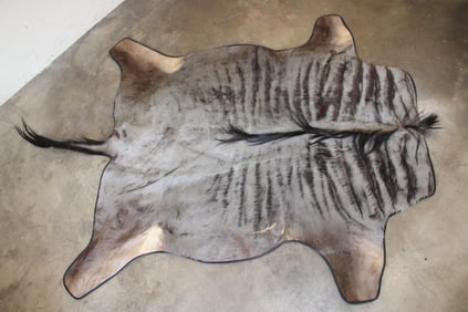 BLUE WILDEBEEST Hide Rug with Leather Piping, a Canvas Backing, and Hanging Loops