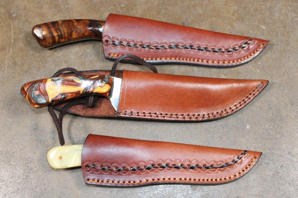 (3) Hand-made KNIVES with Matching Leather Sheaths: 3 Hand-made KNIVES with Matching Leather Sheaths. They measure 8.5" Long (light colored resin handle), 10" Long (brown resin handle), and 10" Long (dyed wood handle). The Total Weight for all is 1 lb