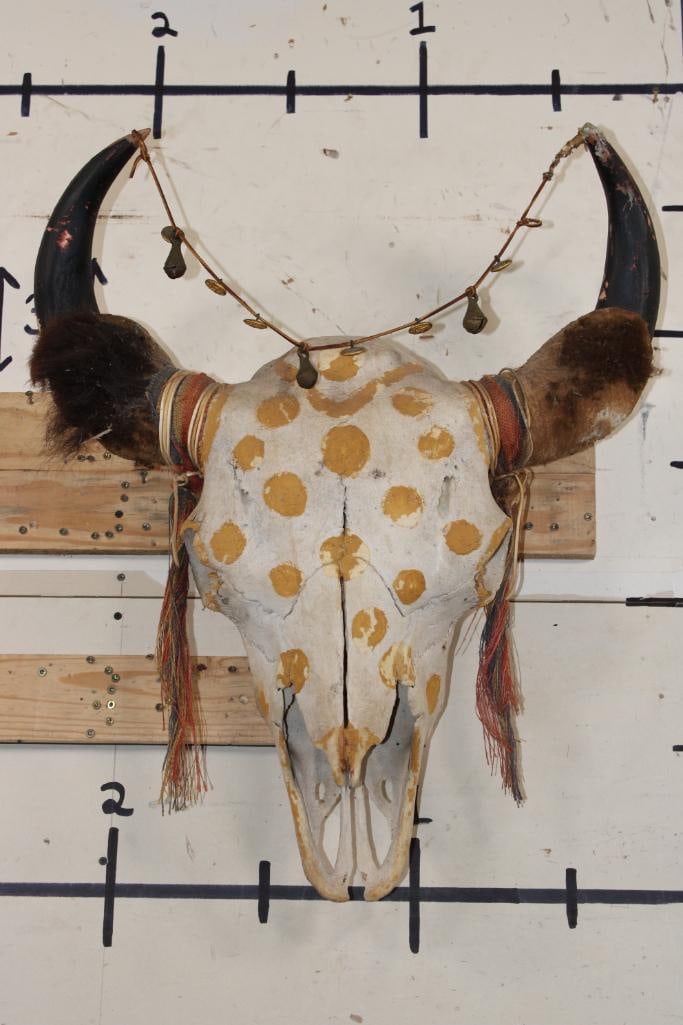 Big Painted and Embellished BUFFALO or BISON Skull: Big BUFFALO or BISON Skull adorned with bells, buttons, fabric, and hide. The horns are made of wood and the skull is painted with yellow gold polka dots. It has a 24" Spread and the Skull measures