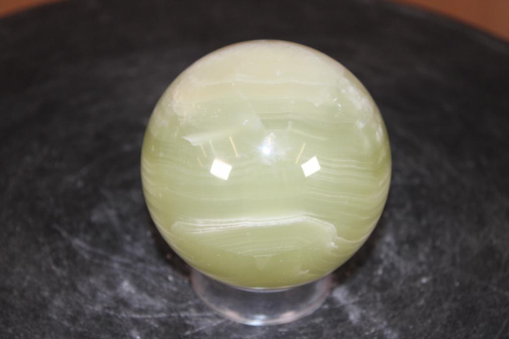 Polished GREEN ONYX Mineral Sphere: Polished GREEN ONYX Mineral Sphere. It measures 3" in Diameter and Weighs 1.3 lbs. It comes with a plastic ring stand for display. ROCKS FOSSILS MINERALS 
