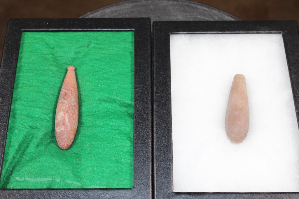 (2) Native American STONE PLUMMETS in Display Cases: (2) Native American STONE PLUMMETS in Display Cases. They measure 3" and 3.5" Long. They are each displayed in Case with Glass that measures 8" Long x 6" Wide. These are made from hard stone. The