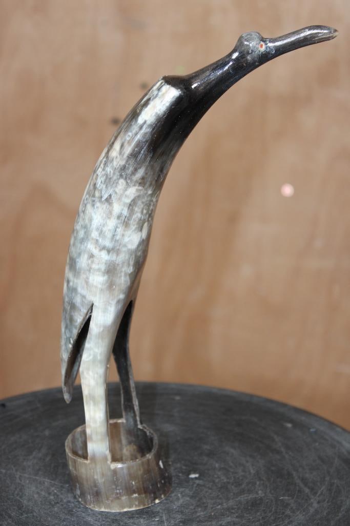 Hand-carved and Polished Steer Horn BIRD Sculpture from Africa: Hand-carved and Polished Steer Horn BIRD Sculpture from Africa. It features an elongated neck, pointed beak, and minimalist body supported by an integrated circular base. It measures 11.25" Tall.