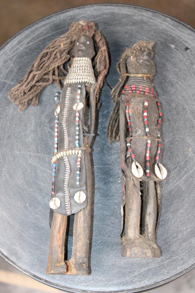 2 Hand-carved Wood Fertility DOLLS from the Turkana People of Africa: 2 Hand-carved Wood Fertility DOLLS from the Turkana People of Kenya. They are embellished with shells, beads, leather, and fibers and appear to be old. They measure 10.5" Tall and 8.75" Tall.