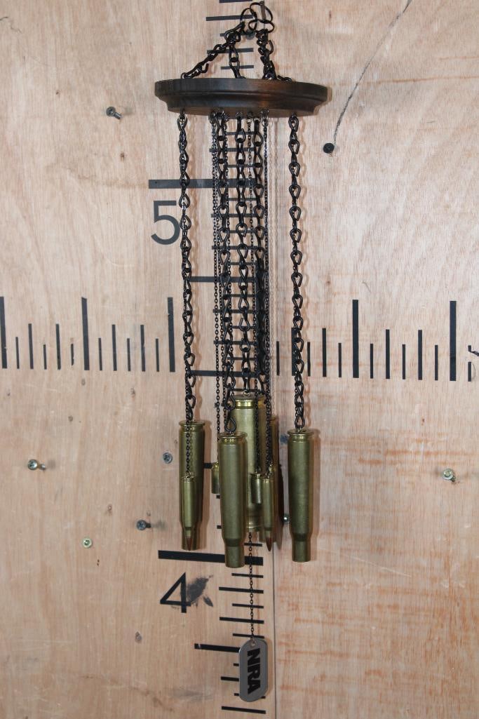 NRA High Caliber WIND CHIMES with Brass Casing or Shells: NRA High Caliber WIND CHIME. It is made with an array of high caliber spent shell casings, including the mammoth 20mm. The weather treated pine base and brass chains also support .50 BMG, .45 ACP and