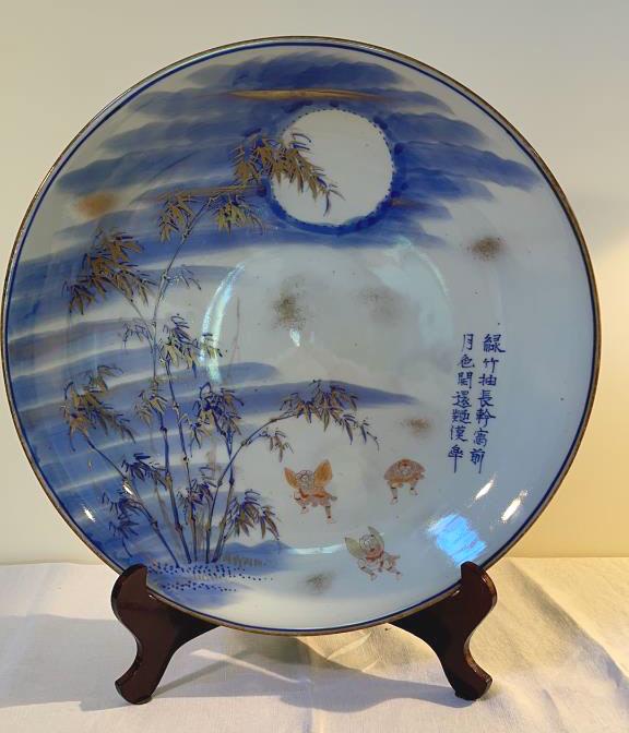Antique Japanese Imari Charger: 18.25 dia. Imari palette of blue underglaze with red overglaze enamels and gilding. Featuring bamboo, moon, and dancers, with story. Very good condition.