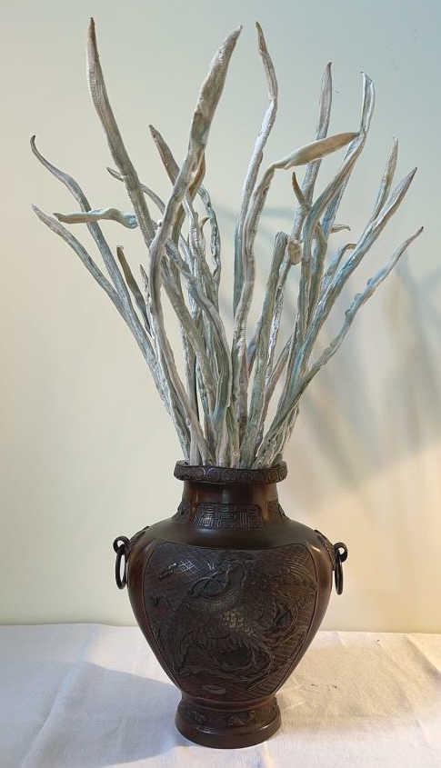 Bronzed Etched Metal Vase: Possibly brass underneath. 12 dia X 13 tall. Etched scenes of bird or dragon, and symbols. Appears to be hand-shaped, Includes contents shown. Inscription on neck and signed on bottom.