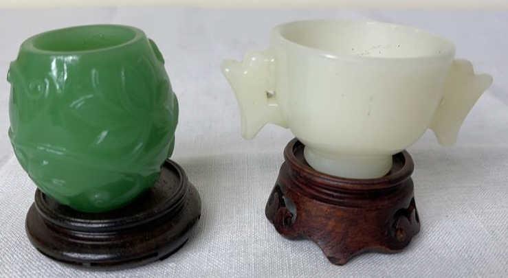 Two Jade Cups on Wood Stands: Embossed green cup 2.24 diameter, white cup is 3.25 wide.