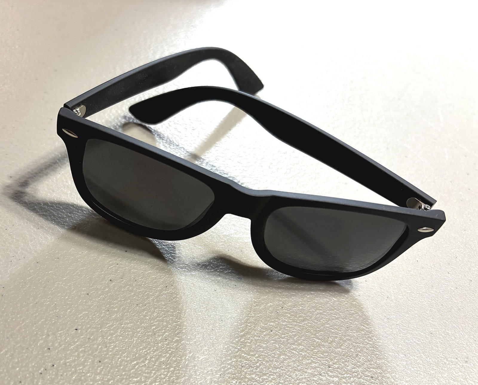 Black Wayfarer Style Sunglasses Matte Frame Dark: A pair of classic wayfarer-style sunglasses featuring a matte black plastic frame with dark tinted lenses and silver-tone hinge hardware. The frame has the iconic squared-off silhouette associated