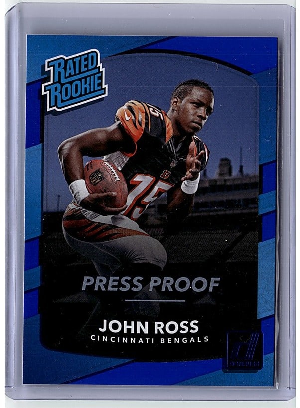 2017 Panini Donruss Optic Rookie Threads John: This is a 2017 Panini Rookie Threads John Ross Press Proof football card in raw condition. The card features the Cincinnati Bengals wide receiver in full action pose wearing his orange and black team