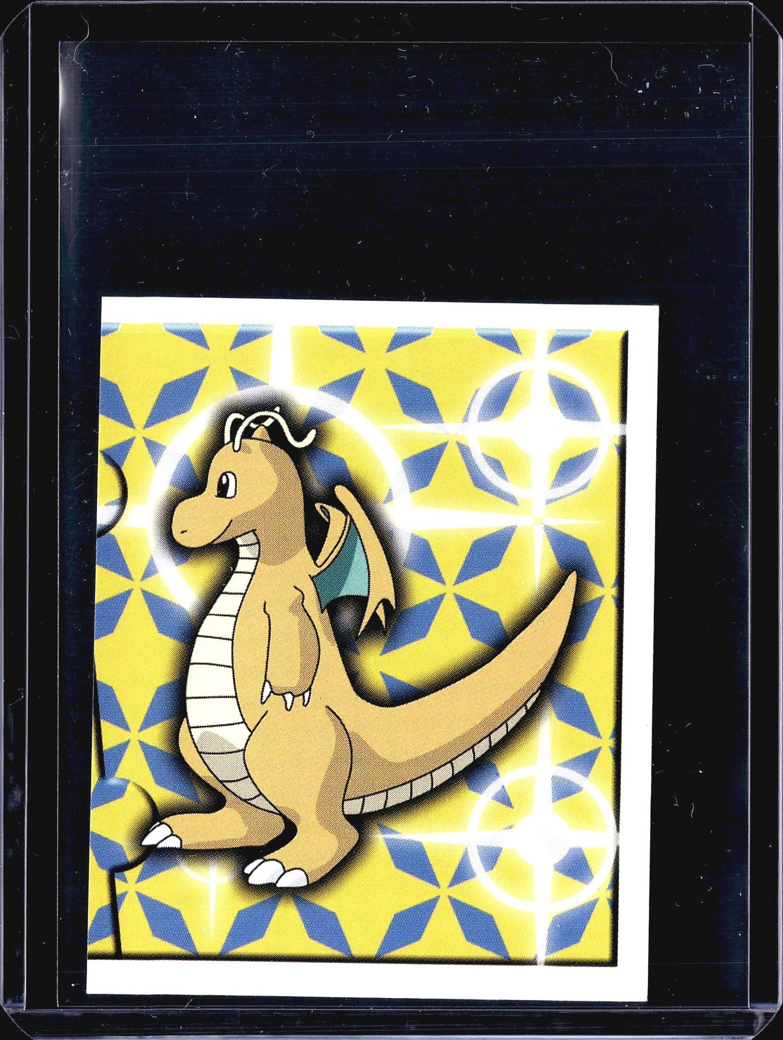 1999 Merlin Pokemon Sticker #164 Dragonite Holo: This is sticker #164 from the 1999 Merlin Collections Pokemon sticker series, featuring Dragonite on a yellow and blue geometric foil background with sparkle/starburst effects. The back displays the s