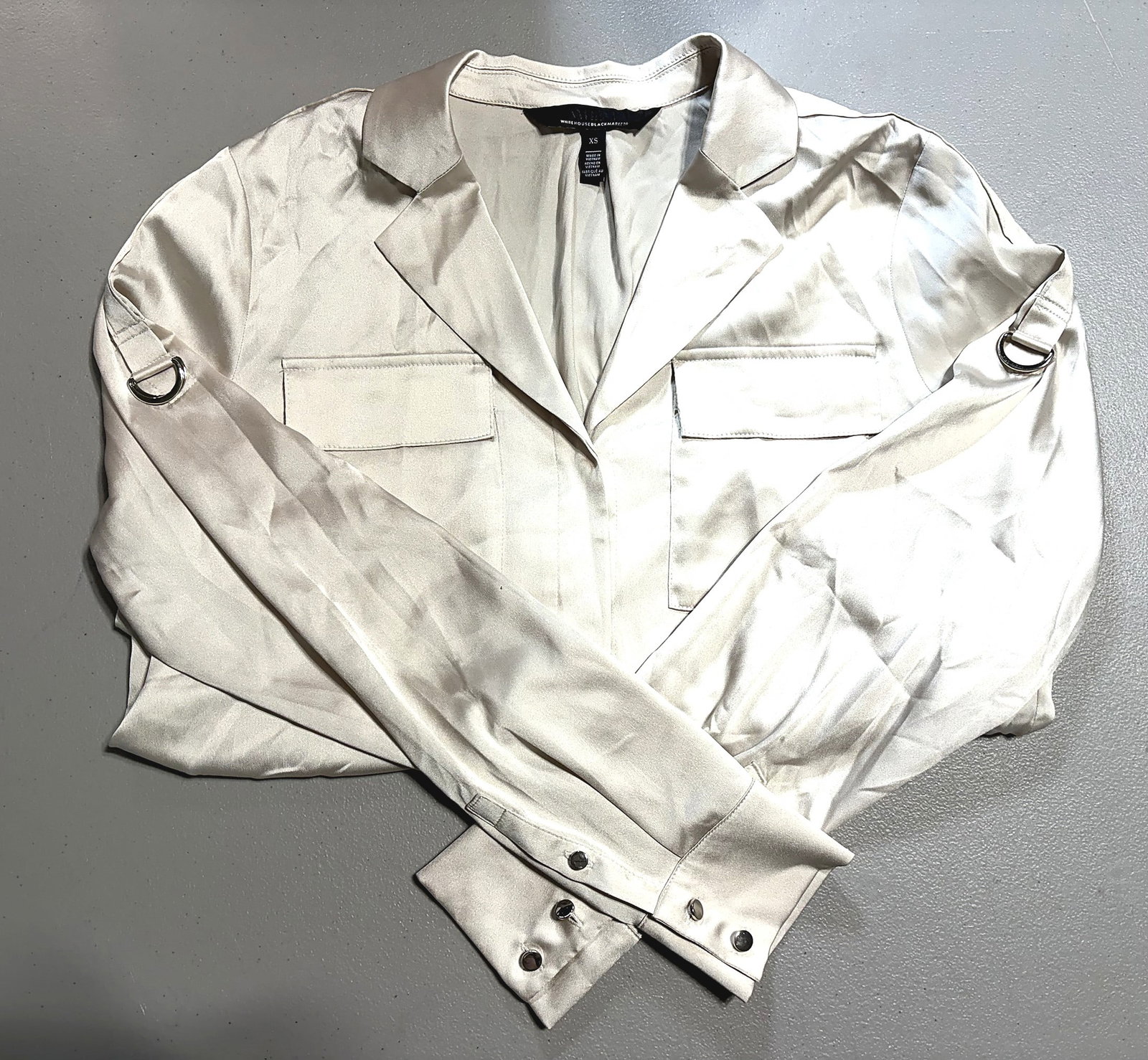 White House Black Market White Satin Blazer: This is a women's size XS satin-finish blazer/jacket from Whouse Black Market (WHBM), featuring a rich ivory/white satin-like fabric with a noticeable sheen. The piece includes notched lapels, two