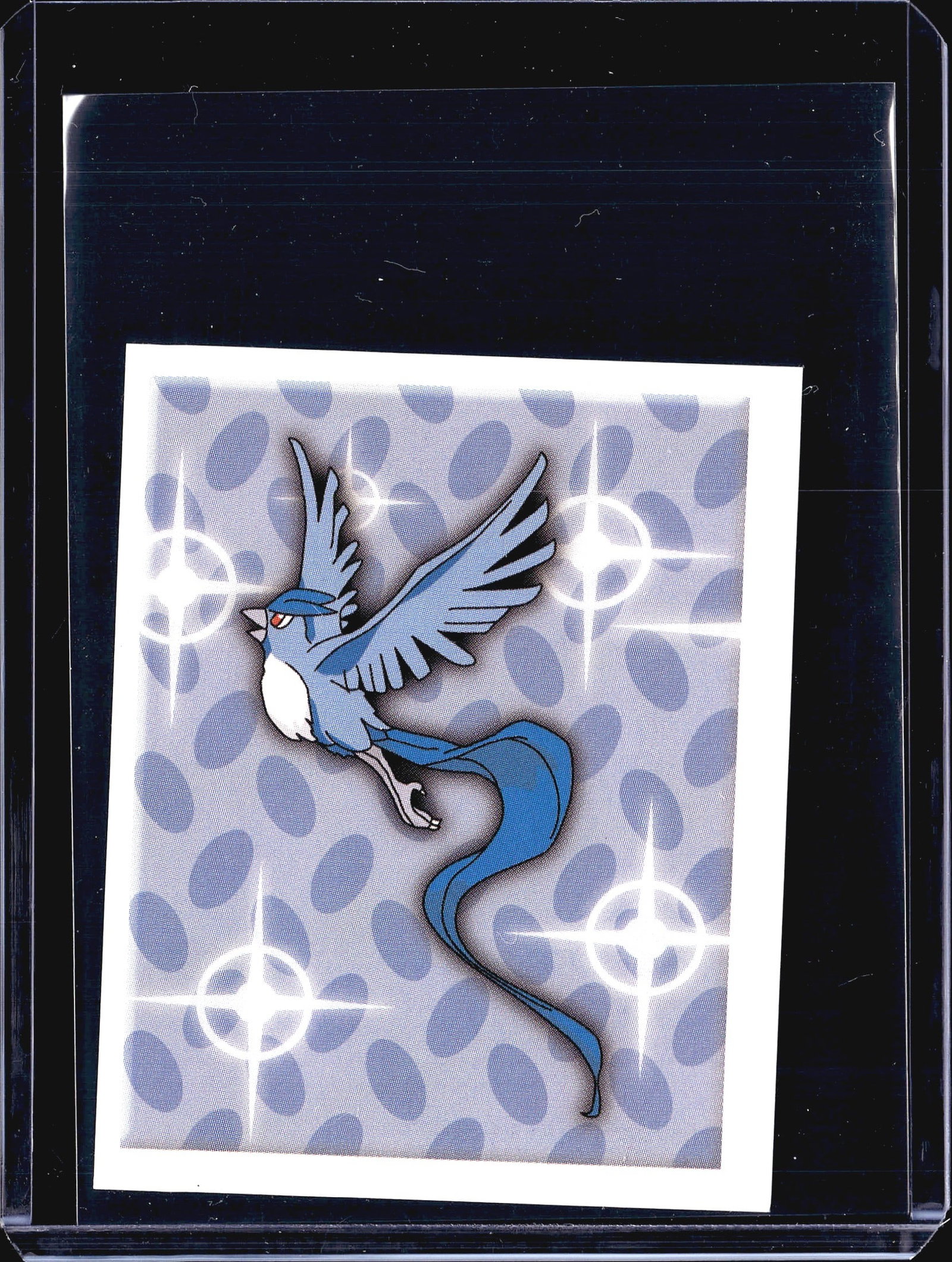 1999 Merlin Topps Pokemon Series 1 Articuno Holo: This is a 1999 Merlin Collections Pokemon sticker featuring Articuno, numbered 203. The front displays Articuno in its iconic blue bird legendary form against a silver holographic dotted background wi