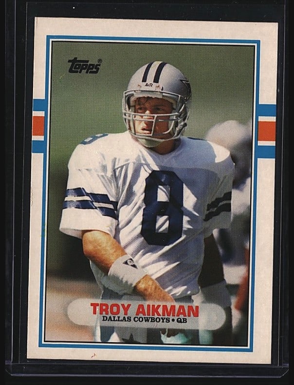 1989 Topps Traded 70T Troy Aikman Rookie Card RC: 1988 Topps Troy Aikman #302 rookie card from the Dallas Cowboys quarterback. This raw single features Aikman in his Cowboys uniform during his debut season. The card displays the classic Topps design 