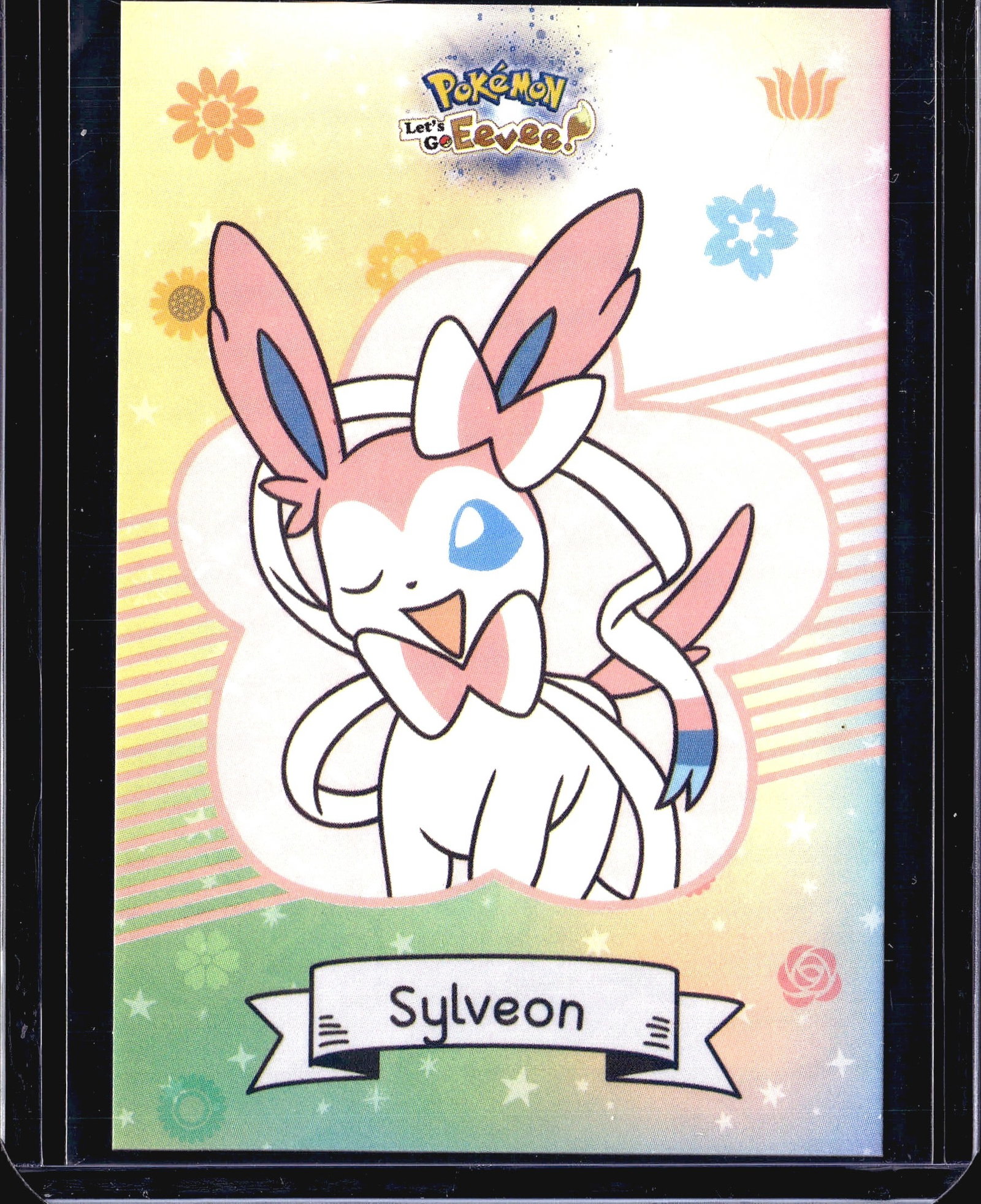 Pokemon Let's Go Eevee Sylveon Single Trading: Single Pokemon trading card from the Let's Go Eevee series, featuring the character Sylveon in the center. The card displays vibrant pastel artwork with floral and nature-themed design elements typica