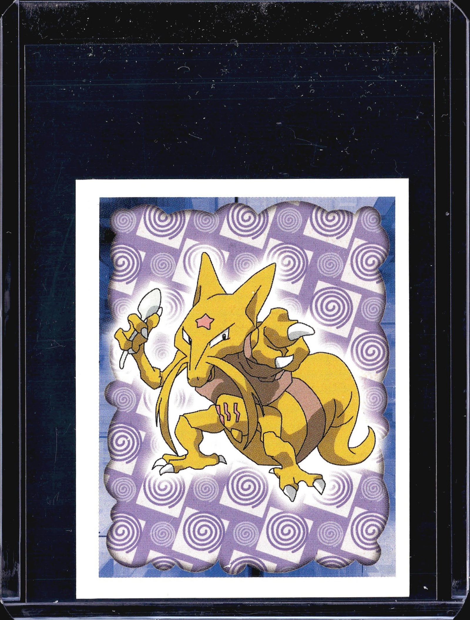 1999 Merlin Pokemon Sticker #64 Kadabra Merlin: This listing features sticker #64 from the 1999 Merlin Pokemon Collections sticker series. The front displays Kadabra, the Psychic-type Pokemon, posed dynamically holding a spoon against a purple swir