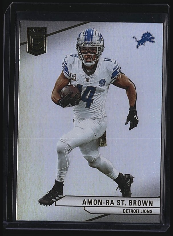 2024 Panini Donruss Elite #87 Amon-Ra St. Brown: 2024 Panini Donruss Elite Football card #87 featuring Amon-Ra St. Brown of the Detroit Lions in white uniform. The card displays St. Brown commemorating the Lions' 2023 playoff appearance with his