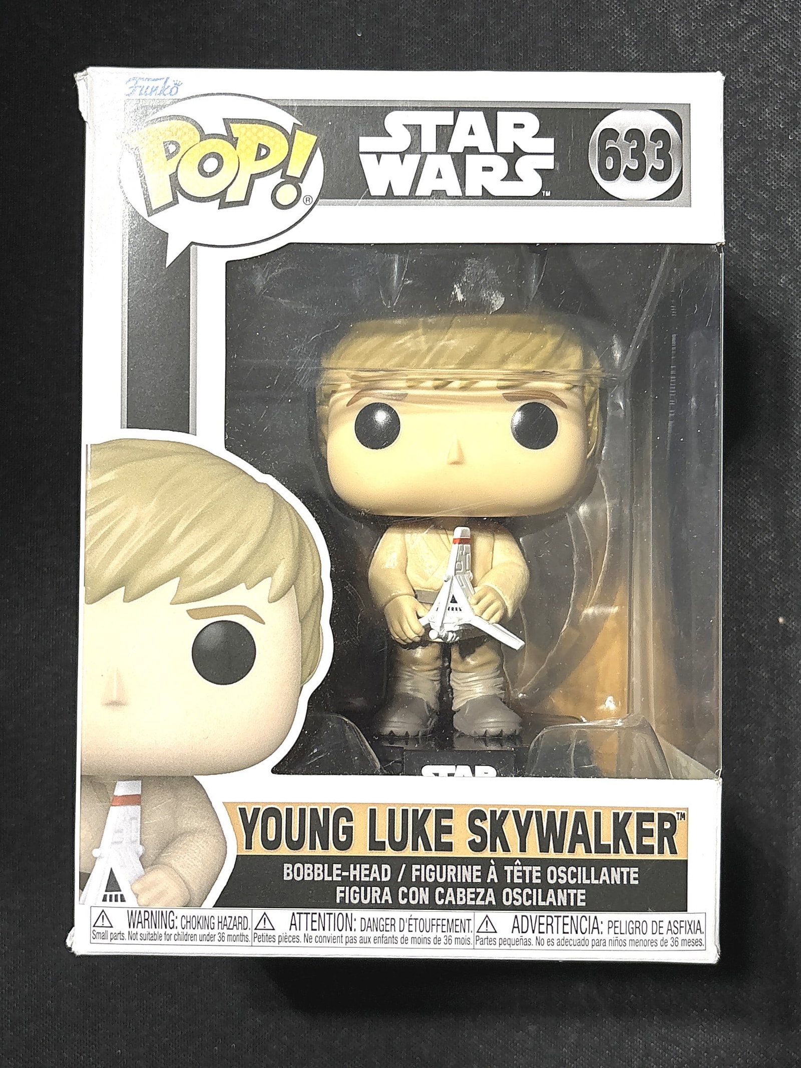 Funko Pop! Star Wars #633 Young Luke Skywalker: Funko Pop! Star Wars #633 Young Luke Skywalker bobble-head vinyl figure, shown in its original window box. The figure depicts a youthful Luke Skywalker in tan Tatooine-style farm clothes and boots, ho