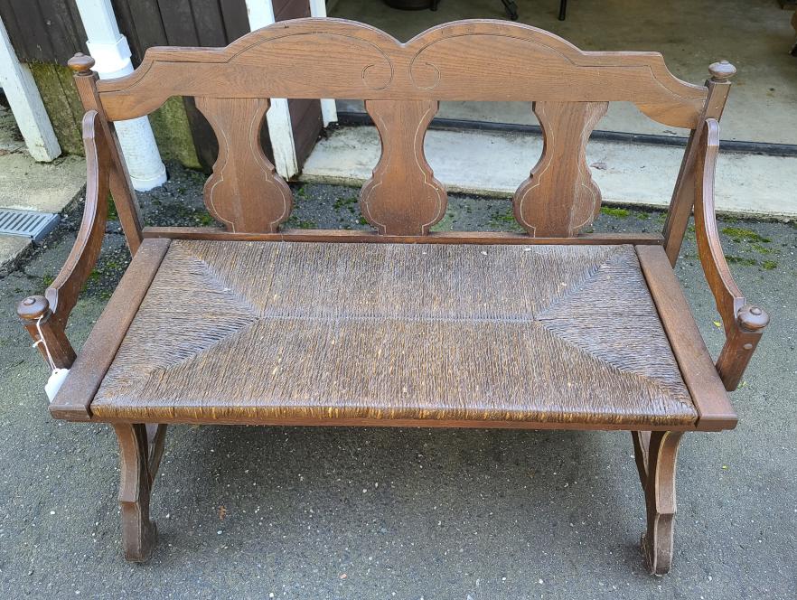 Vintage Wooden Bench: Description: This lot includes a vintage wooden bench. Bench features a caned seat and metal support underneath.Condition: Bench is in fair vintage condition. In need of a good cleaning.Shippable Item