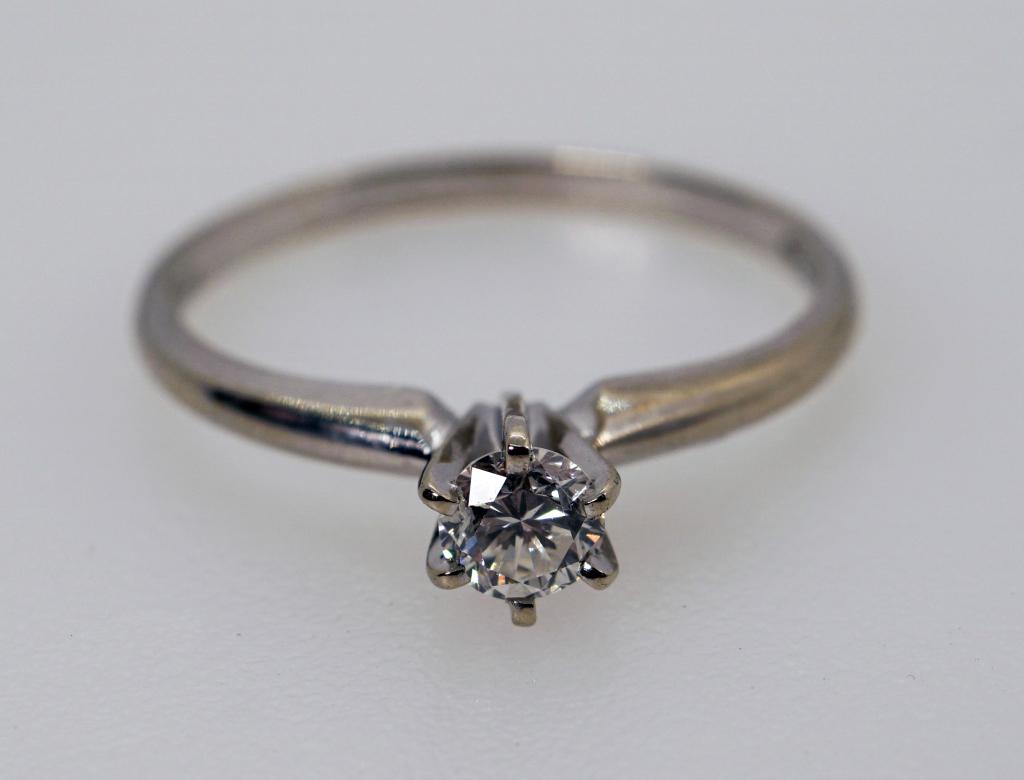 14K White Gold Solitaire Engagement Ring by Tru Glo: Description: This lot includes a 14K white gold diamond ring by Tru Glo. The ring features a .31 cts diamond. Lot includes a jewelers appraisal certificate Condition: Overall very good condition. Size