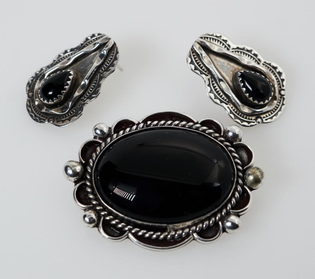 Navajo New Mexico Sterling Silver & Onyx Jewelry Set: Description: This lot includes a small jewelry set made of Sterling silver, and smooth cut onyx stones. The Brooch was made by artisan David Fletcher Garcia (DFG), and the earrings by James Toadlena (