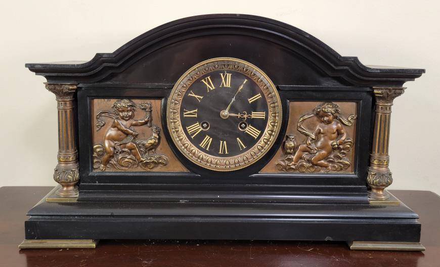 French Slate & Bronze Mantel Clock: Manufacturer: Bigelow Kennard & Co. Features & Details: -Made in France -Made of heavy black slate -Highly detailed bronze decorations Measurements: 18"L x 6"W x 10.5"H Condition: The clock is in good