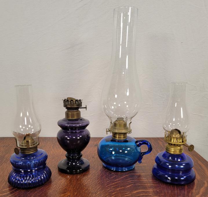 4 Antique Blue Glass Oil Lamps: Description: This lot includes 4 antique oil lamps with blue glass bases. Condition: Each lamp is in overall good, used condition. Missing one chimney 3rd Party Shipping available for this lot - Conta