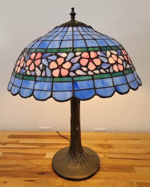 Vintage Leaded Glass Table Lamp: Description: This lot includes a leaded glass table lamp with blue & pink floral designs throughout and a bronze colored base. Appears to age to the late 20th century Condition: Minor Expected surface