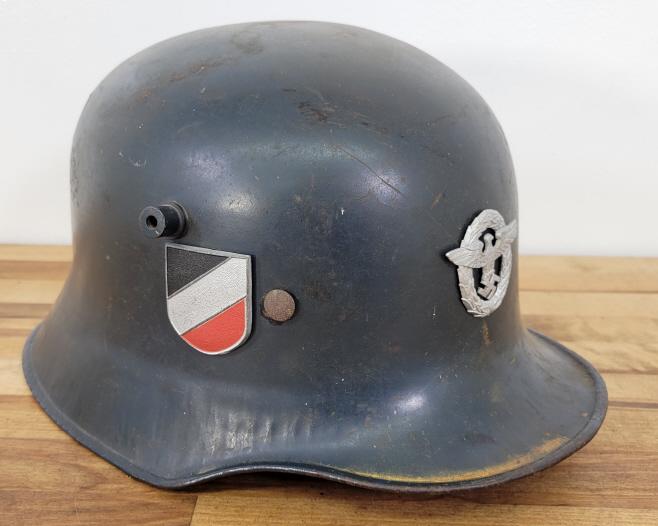 German M18 Combat Helmet: Description: WWII German M18 combat helmet with two metal decals on front and right side. Includes liner in overall fair condition with no strap.