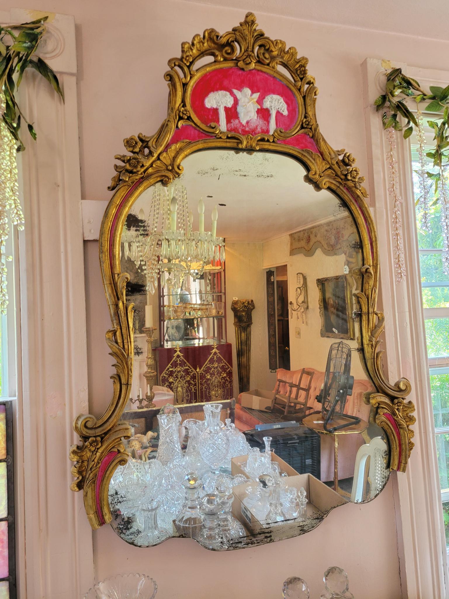 Victorian Gilt Wood Wall Mirror: Description: This lot includes a Victorian gilt wood wall mirror. The mirror has been painted a few times, and had decorations added to the top panel. Missing the bottom section of the frame. Conditio