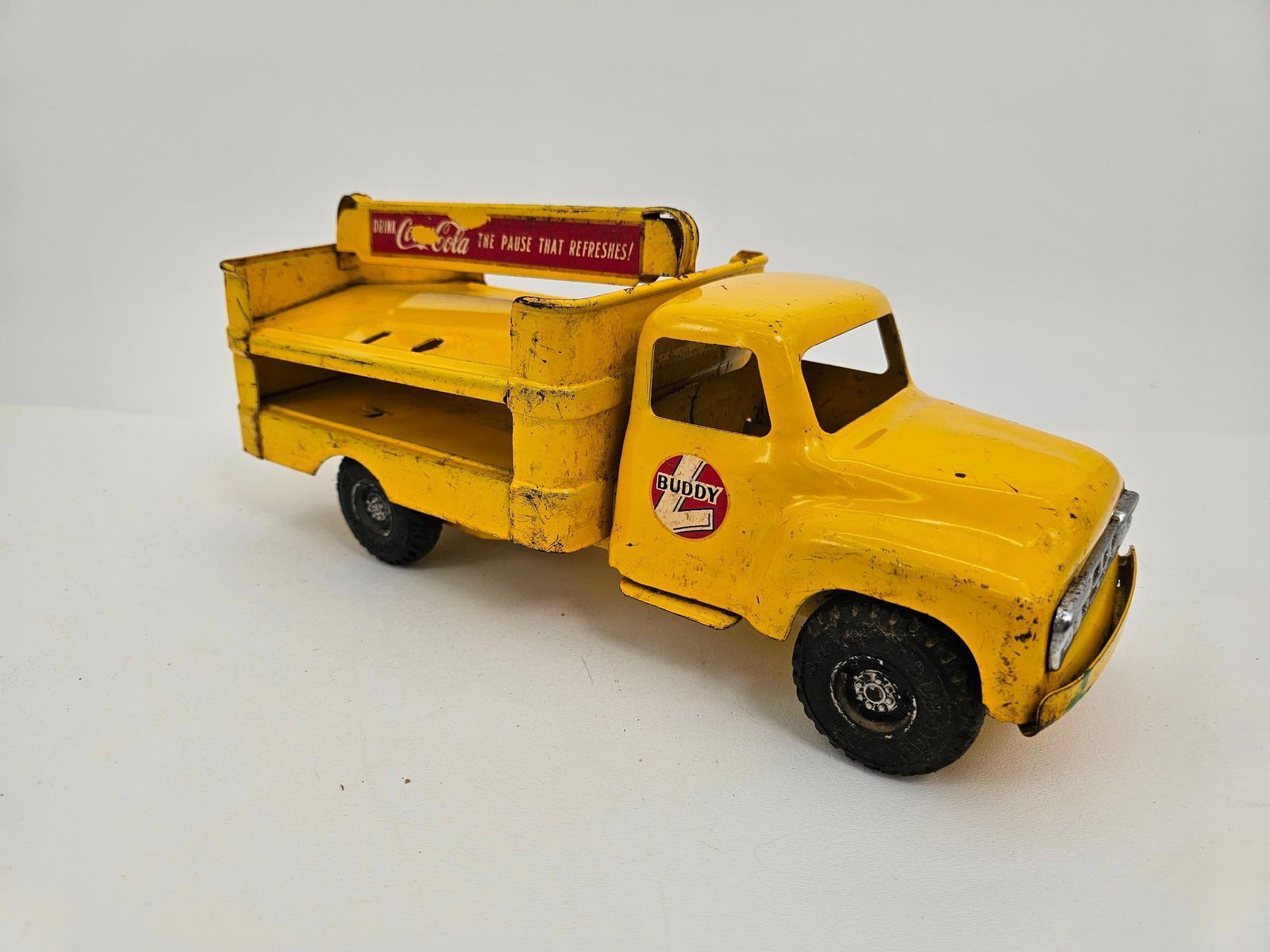 Buddy L Pressed Steel Coca-Cola Delivery Truck: Description: This lot includes a pressed steel Coca-Cola delivery truck made by Buddy L. The truck is in original played with condition with some paint loss from age and use.For an in-depth understand