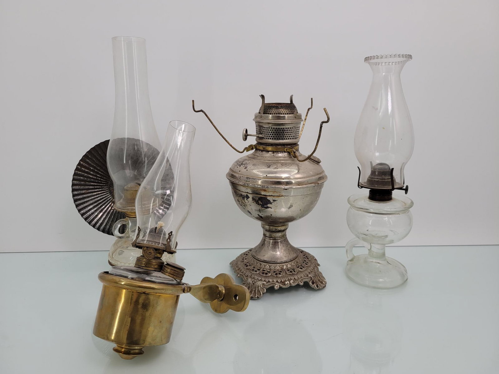 (4) Four Antique Oil Lamps: Includes are four various types of antique oil lamps. All but one includes a chimney. Untested but in overall good cosmetic condition.
