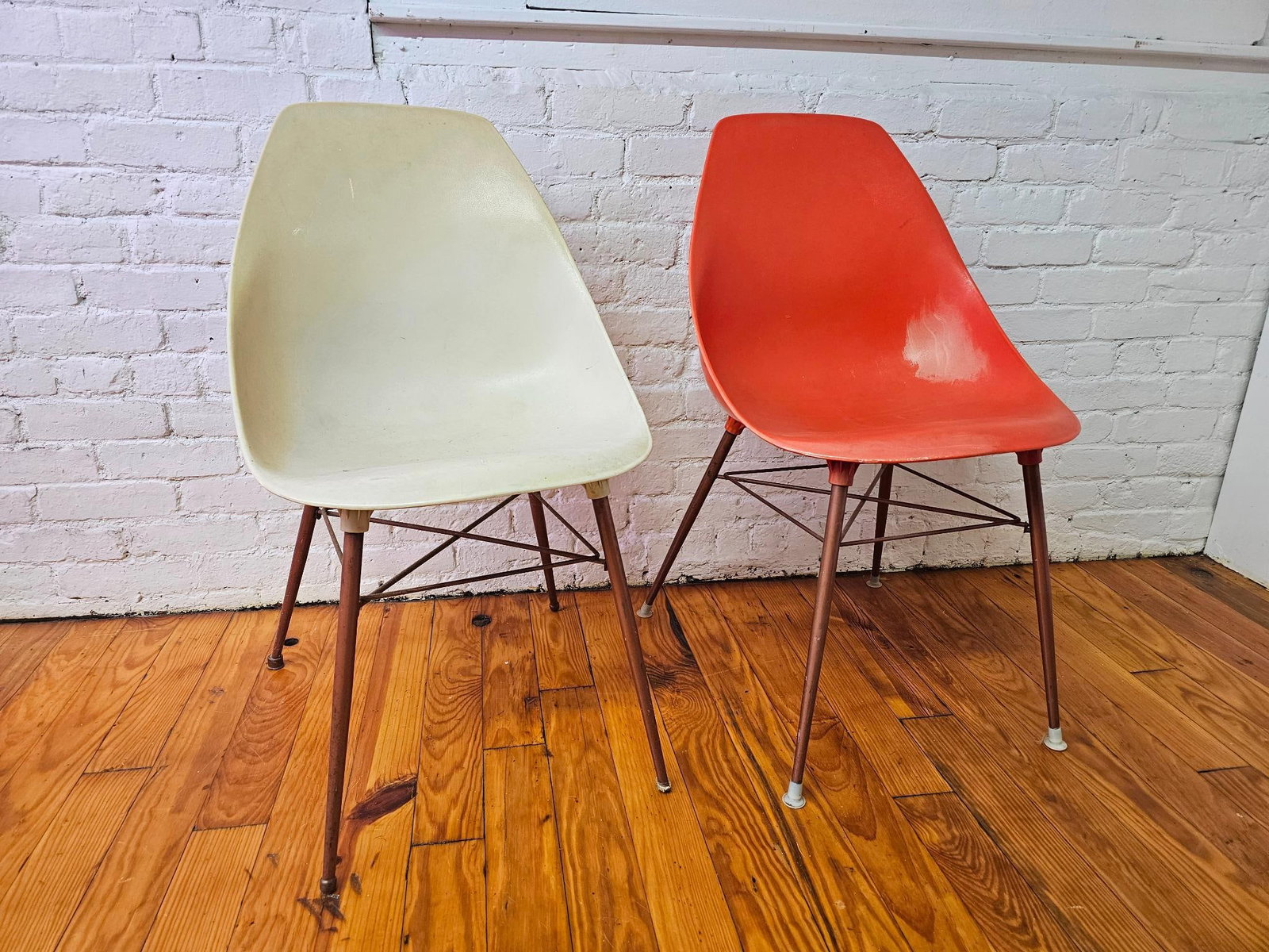 Mid Century Sam Avedon Aladdin Plastic Chairs: The pair of chairs are by Sam Avedon, made of plastic and offered in vintage as found condition with some staining and marks to the plastic, the orange chair has either a sanded spot or paint stain. S