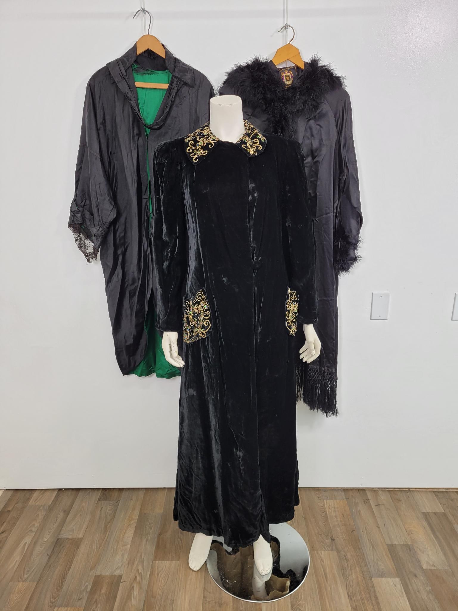 Trio Of Vintage Opera Coats: Description: Three black opera coats. First one lined in green with lace accents and fancy fringe around collar. No label. Lining and sleeves are damaged. Second by Oppenheim, Collins and co. Appears 