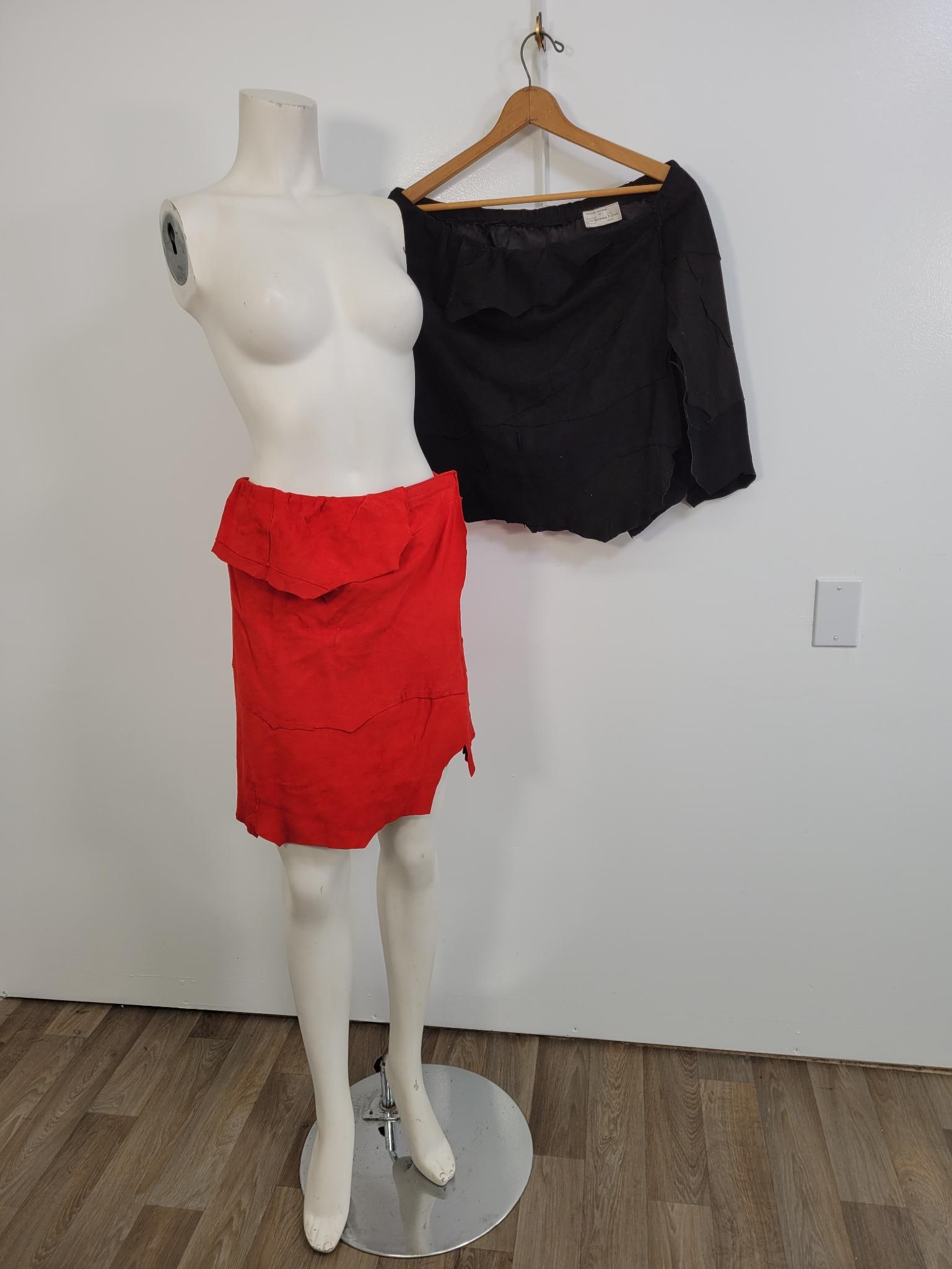 Pair of Jeanne Ross Short Suede Skirts: Description: Pair of red and black suede short skirts. Elastic waist, with Velcro closure(see photos) No stains or rips. Measurements: 40" elastic waist